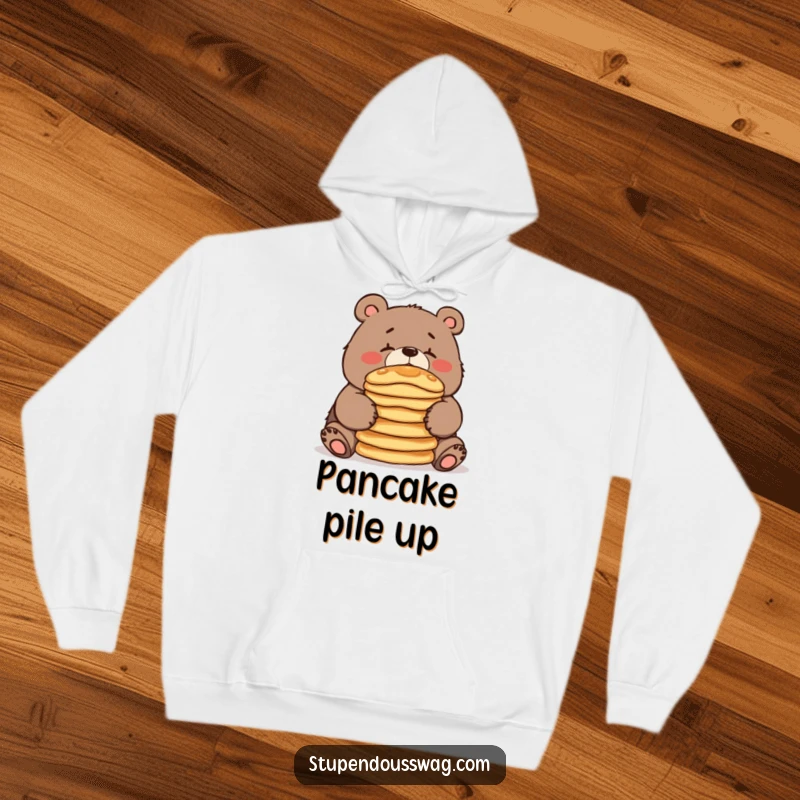 A soft, warm hoodie featuring a clumsy bear struggling to balance pancakes on its nose, perfect for cozy, humorous moments.