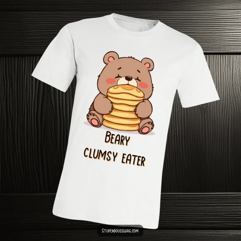 A clumsy bear precariously balancing a tall stack of pancakes on its nose, printed on a funny and relatable t-shirt.